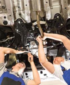 Two men repairing a car