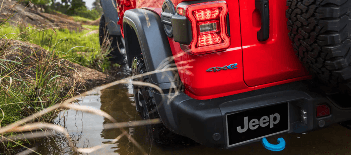 Red 2025 Jeep Wrangler 4xe driving through water