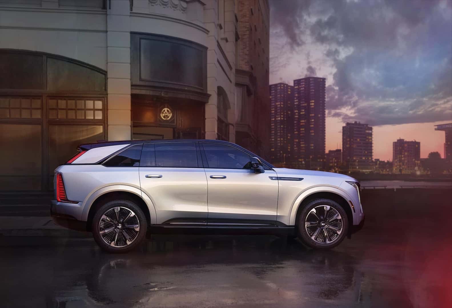 Full side view of 2025 Cadillac ESCALADE IQ Sport in Flare Metallic at sunset.