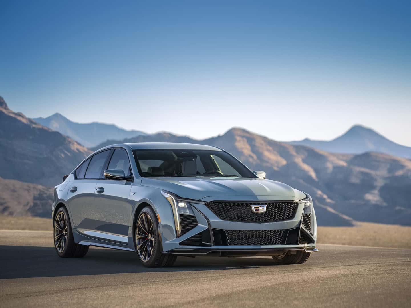 Front 3/4 view of the 2025 CT5-V Blackwing in Drift Metallic with the sky and mountains in the background.