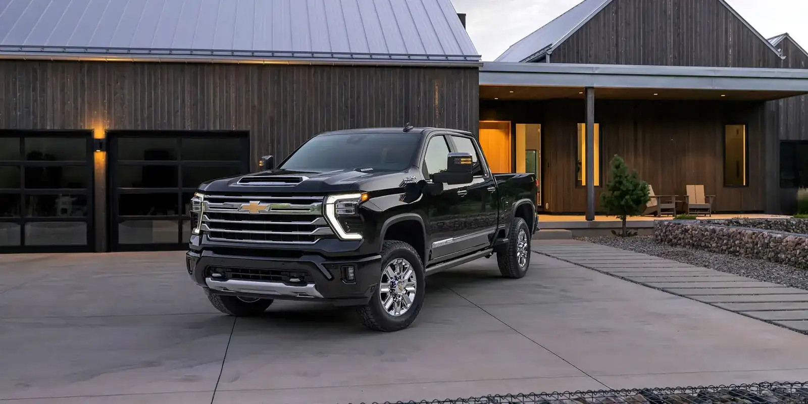 Black 2026 Chevrolet Silverado HD High Country parked outside a modern barn