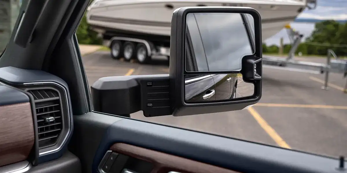 View from a Chevrolet Silverado HD tow mirror of a boat on a trailer behind the truck