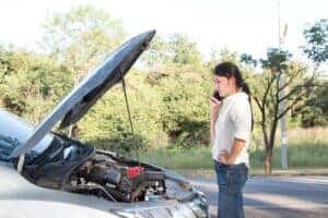 Woman standing near overheated car