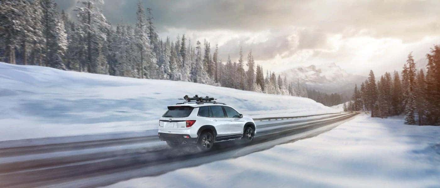 White Honda vehicle on a snow covered highway