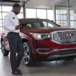 Certified technician inspecting a GMC SUV inside the service center at Greg Hubler Buick GMC