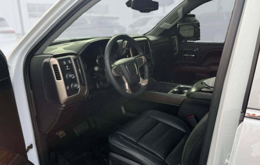 Interior cabin view of a used GMC Sierra showing seats steering wheel and dashboard