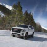 GMC SUV driving on winter roads in snowy conditions