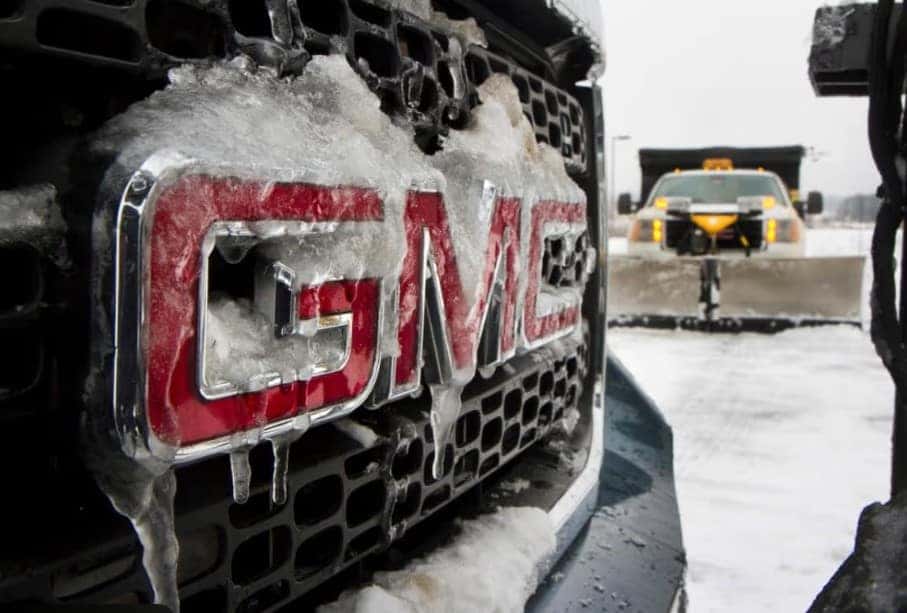 GMC vehicle front grille covered with ice and snow during winter driving
