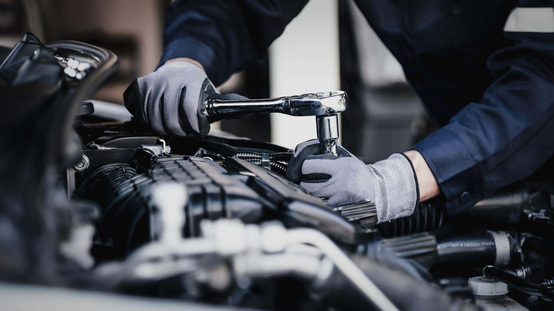 A mechanic working on an engine of a vehicle.