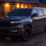2025 Jeep Wagoneer exterior in black parked in front of a cabin