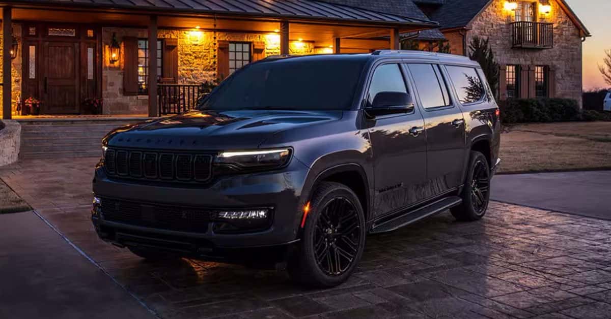 2025 Jeep Wagoneer exterior in black parked in front of a cabin