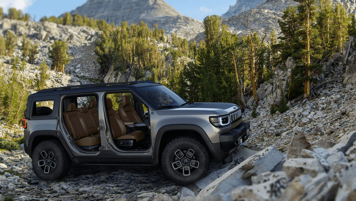 Jeep recon without any doors driving over a riverbed in the forest