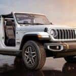 Jeep Wrangler SUV with the doors off driving on the beach