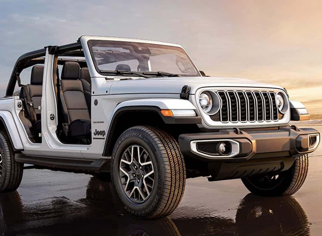Jeep Wrangler SUV with the doors off driving on the beach