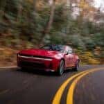 2026 Dodge Charger driving down tree lined road