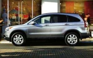 A Honda CR-V parked outside a downtown retail space.