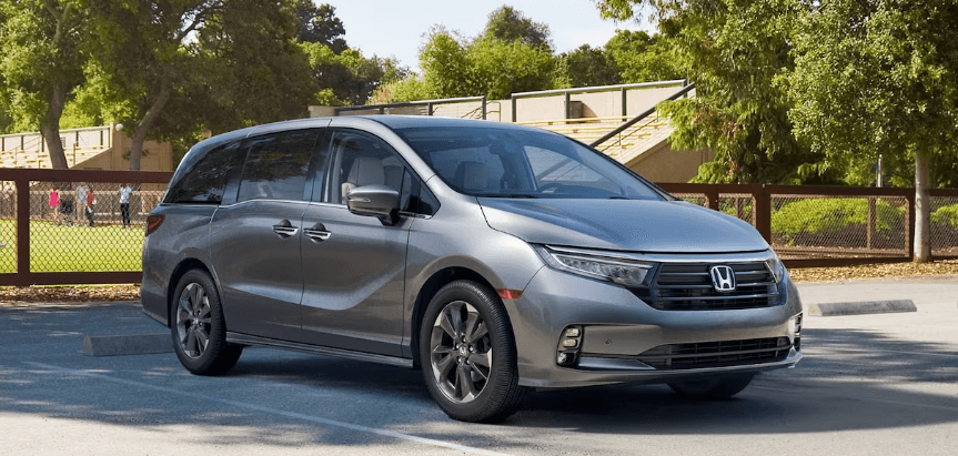 Gray paint 2024 Honda Odyssey parked in front of a kids sports game.