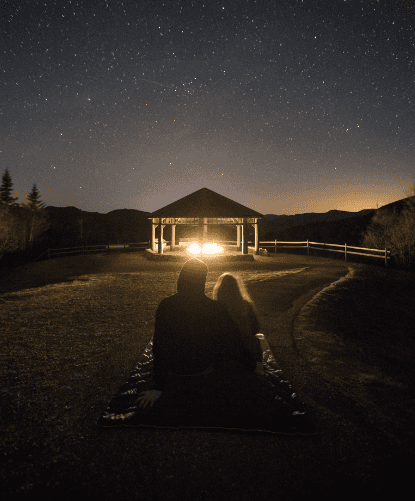 Couple sitting on the mat at night stargazing in Marion, IL
