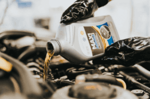 Closeup photo of someone pouring oil into their Honda vehicle.