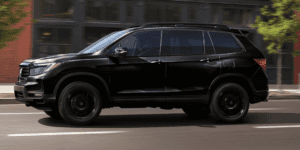2025 Honda Passport in black paint driving down a Southern Illinois city road.