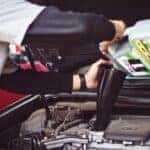 mechanic adding engine oil to a car's engine