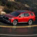 red 2026 Honda Pilot SUV driving down the road