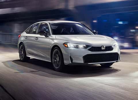 white 2026 Honda Civic Hybrid driving down the road