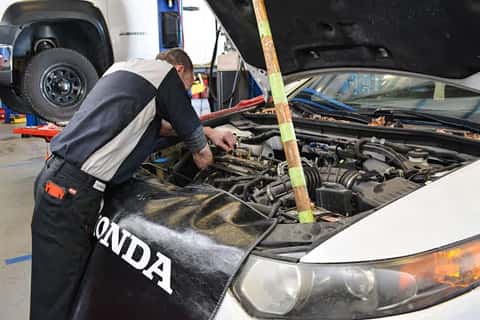 Honda maintenance tech working on a vehicle at the Ike Honda service center in Marion, IL