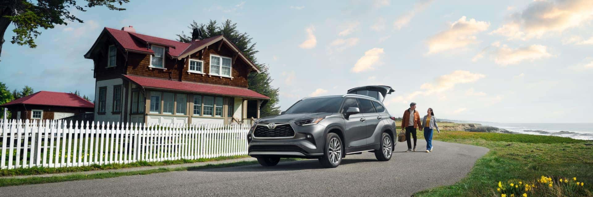 Couple walking to their Toyota Highlander with coastal scenery