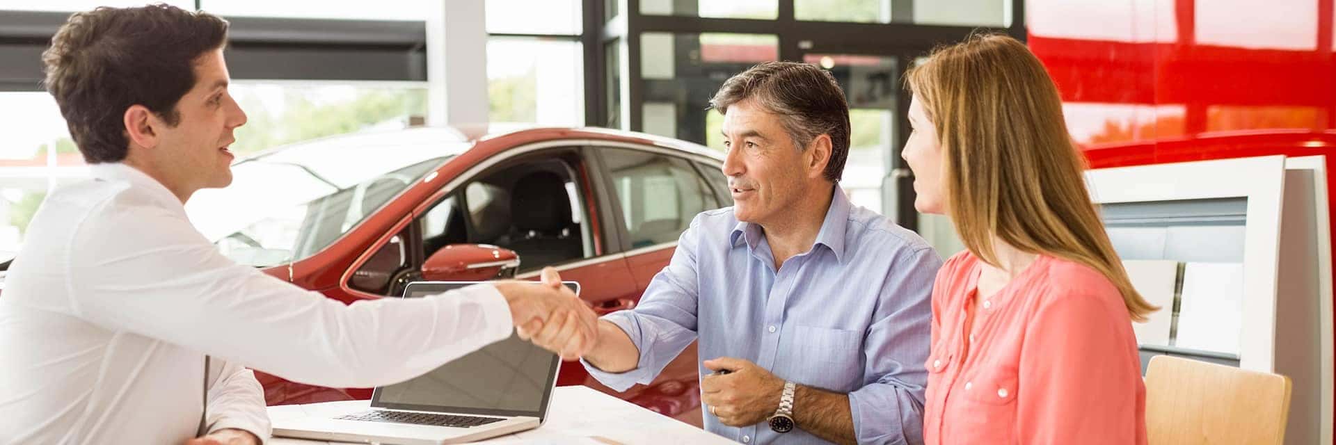 couple talking to a salesman at dealership
