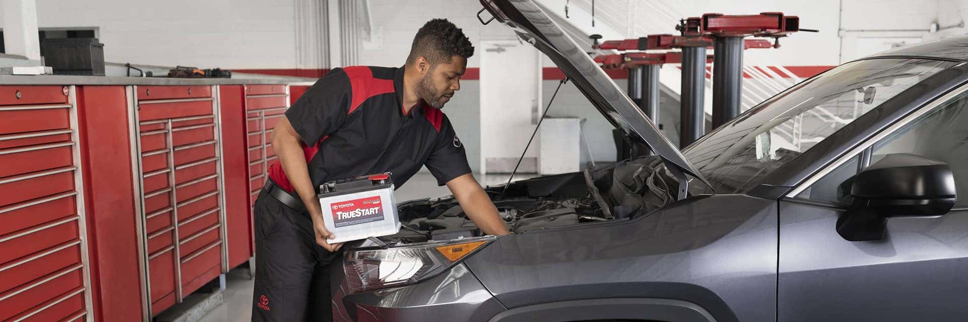service technician changing car battery