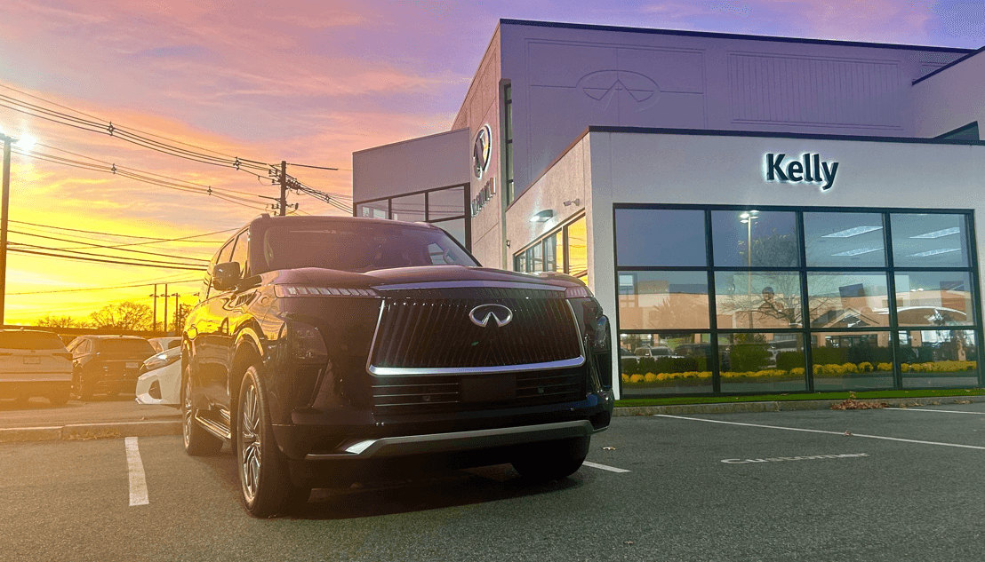 Sunset at Kelly INFINITI with 2025 INFINITI QX80 in front of dealership
