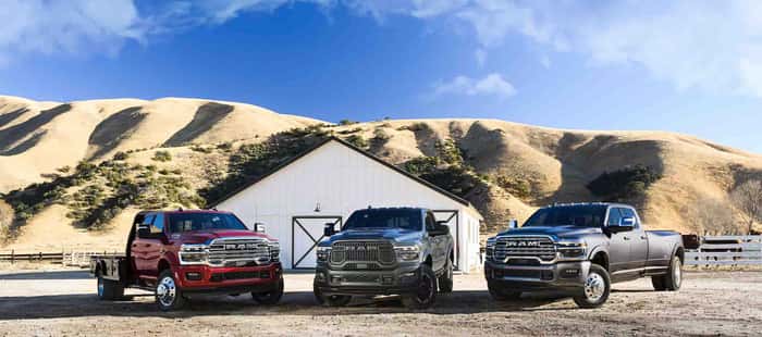 3 ram trucks parked in front of barn