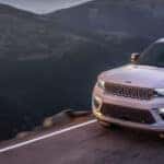 White Jeep Grand Cherokee driving on the road