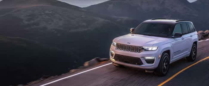 White Jeep Grand Cherokee driving on the road