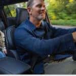 Driver and rear passenger inside the black leather interior of a 2026 Jeep Grand Cherokee L.