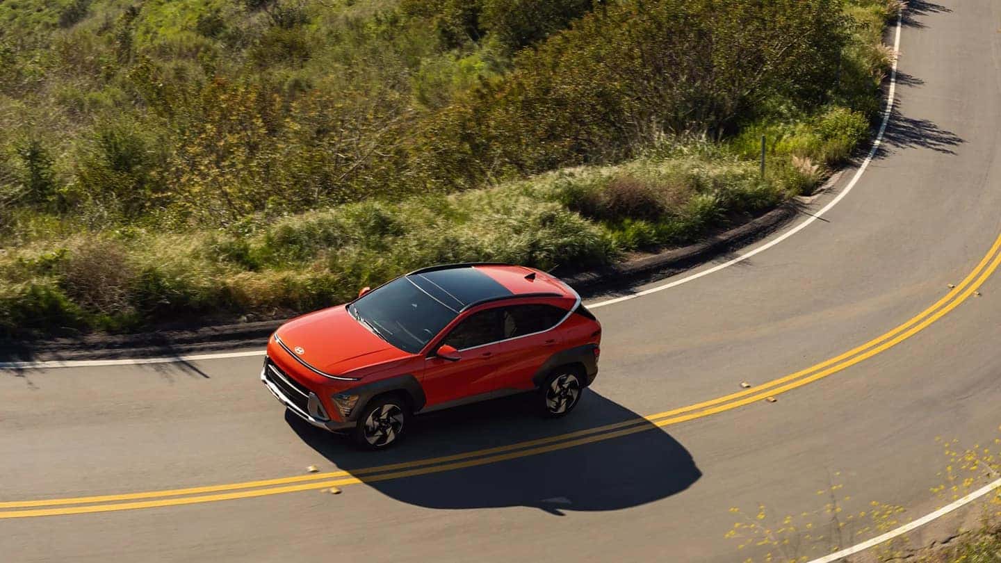 An overhead image of an orange 2025 Hyundai Kona driving down the street