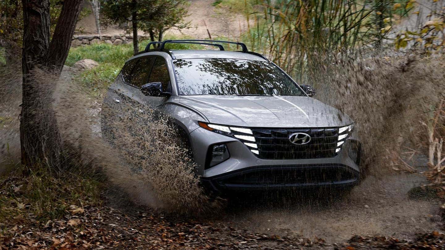 A gray 2024 Hyundai Tucson driving through mud