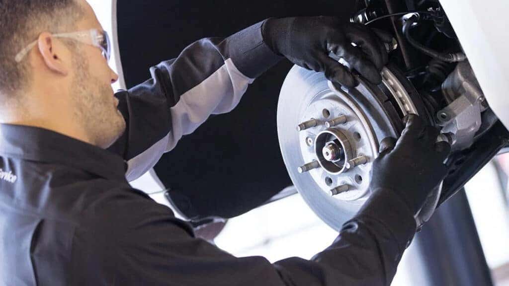 A technician performing routine brake service on a vehicle