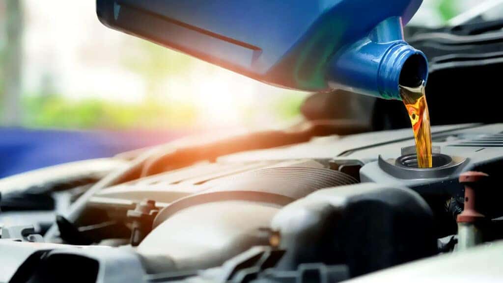Clean engine oil being poured as part of a regular oil change