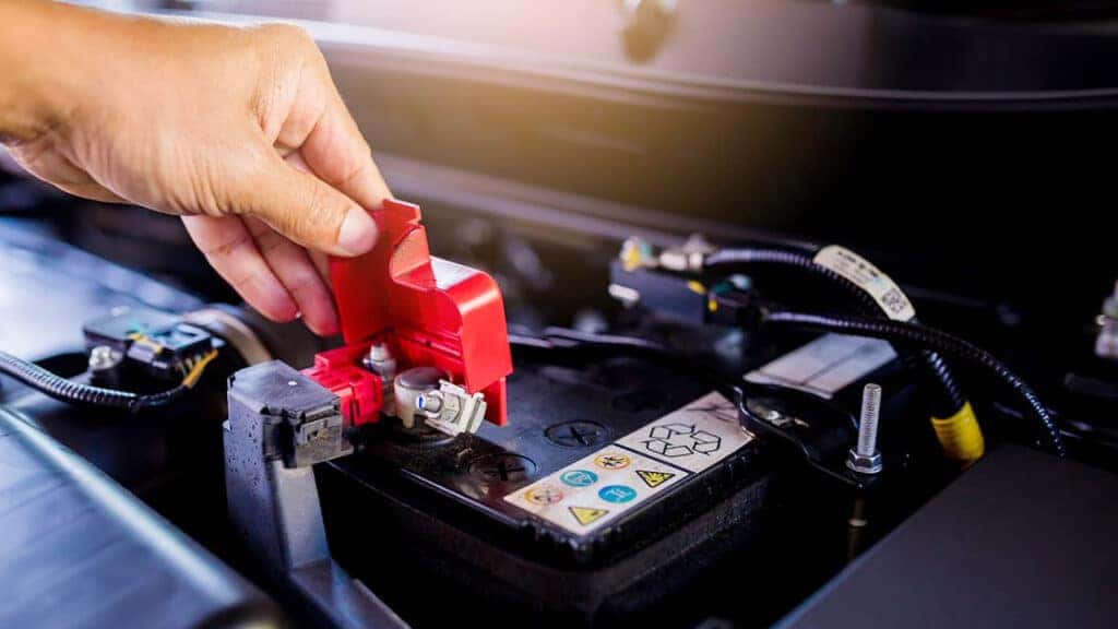 A technician inspecting a car battery