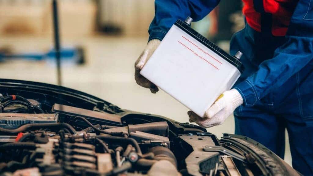 A technician replacing a car battery