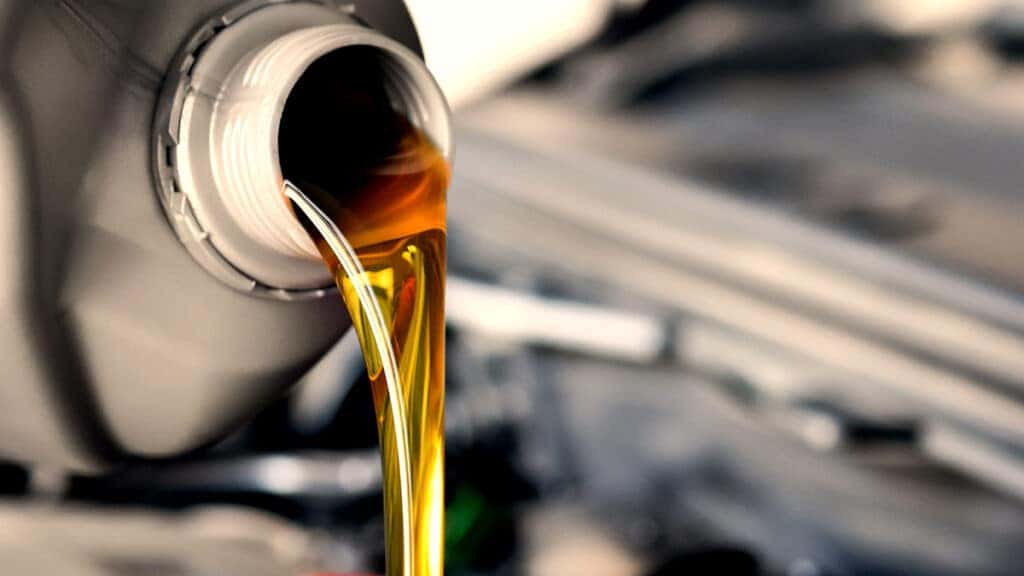Clean engine oil being poured as part of a regular oil change