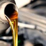 Clean engine oil being poured as part of a regular oil change