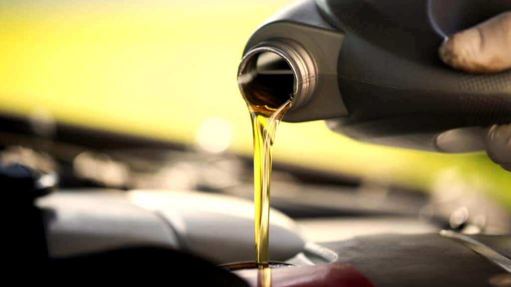Clean engine oil being poured as part of a regular oil change