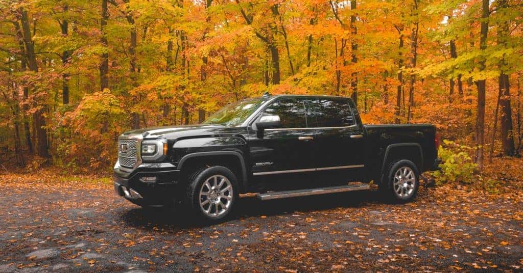 a new GMC Sierra sitting on a back road with changing leaves behind it in Perry Oklahoma