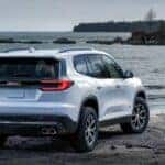 White GMC Acadia SUV Water Rocks Trees