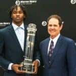 Jeremiah Smith receiving the Warren H. Zinn Player of the Year Award, standing next to Warren H. Zinn, the CEO of Warren Henry Auto Group.
