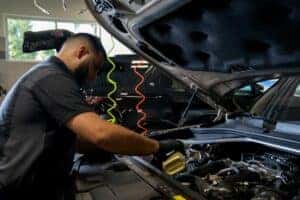 Jaguar Land Rover Certified Technician pouring oil into the valve.